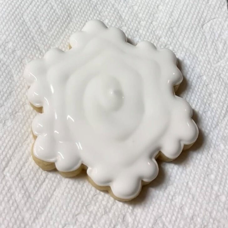 Step-by-step decorating instructions for how to decorate snowflake cookies with royal icing