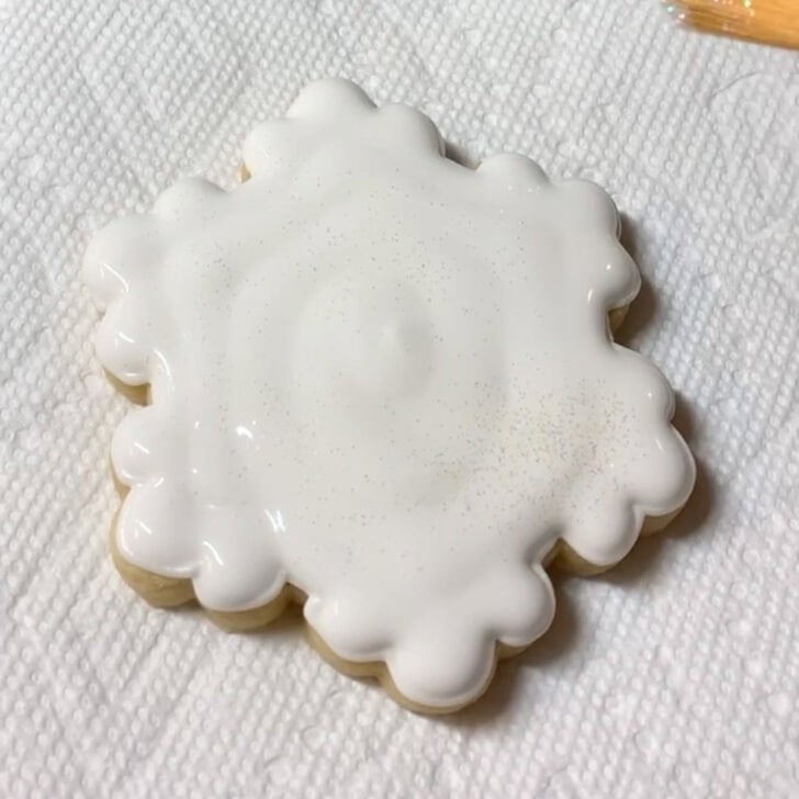 Step-by-step decorating instructions for how to decorate snowflake cookies with royal icing