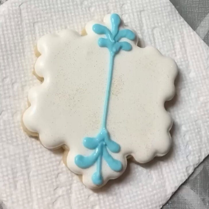 Step-by-step decorating instructions for how to decorate snowflake cookies with royal icing