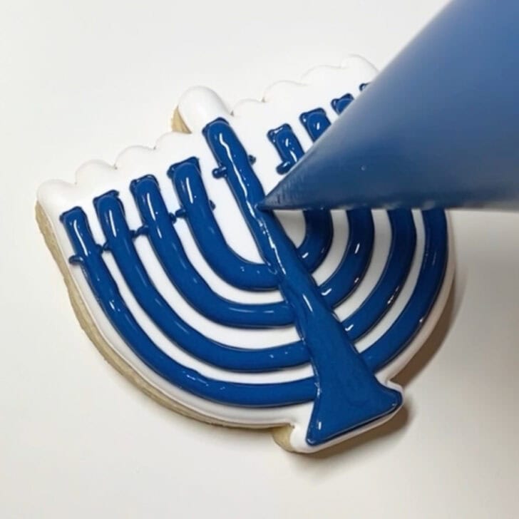 Step-by-step decorating instructions for how to decorate menorah cookies with royal icing