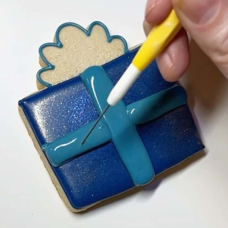 Step-by-step decorating instructions for how to decorate present cookies with royal icing