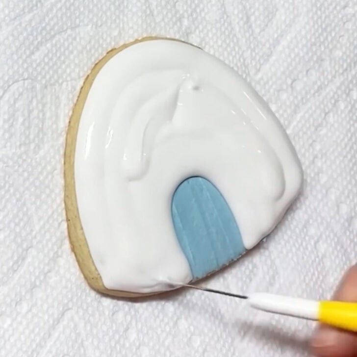 Step-by-step decorating instructions for how to decorate igloo cookies with royal icing