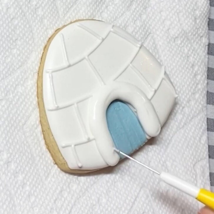Step-by-step decorating instructions for how to decorate igloo cookies with royal icing