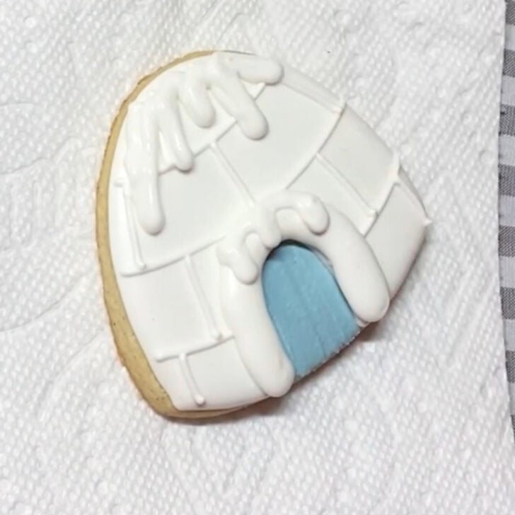 Step-by-step decorating instructions for how to decorate igloo cookies with royal icing
