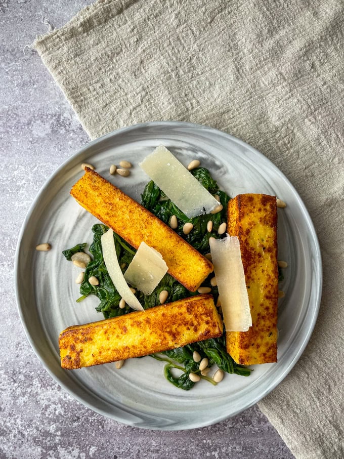 אצבעות פולנטה על מצע של תרד מוקפץ וצנוברים