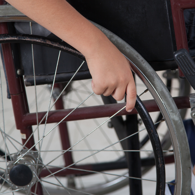 kid's hand on wheelchair