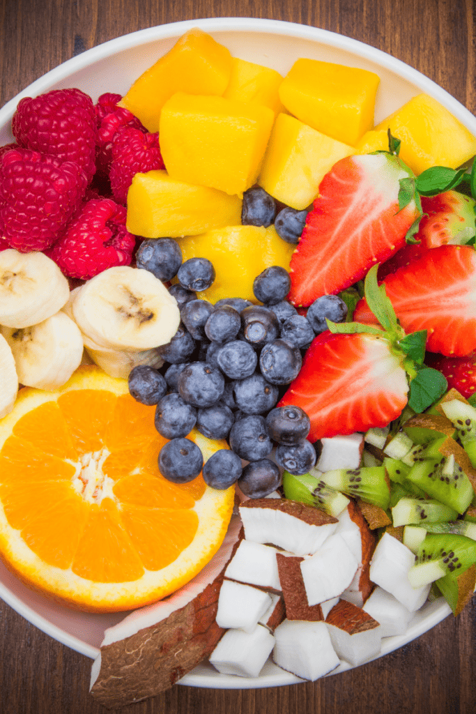 The Best Ways to Boost Your Immune System. Bowl of fruit with mango, berries, banana, orange and coconut.