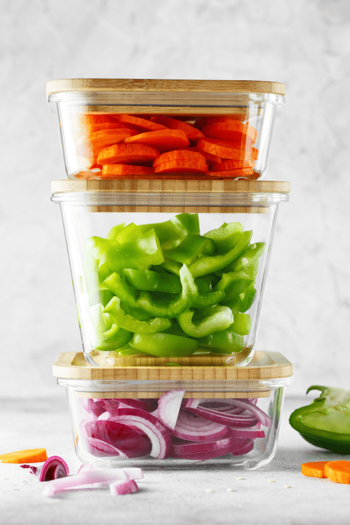 10 Tips for Easy Meal Prep. A stack of glass containers filled with cut veggies.