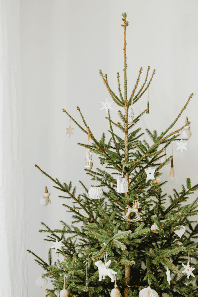 Holiday Bucket List Ideas for a Memorable Season. Christmas tree with white ornaments, simply decorated.