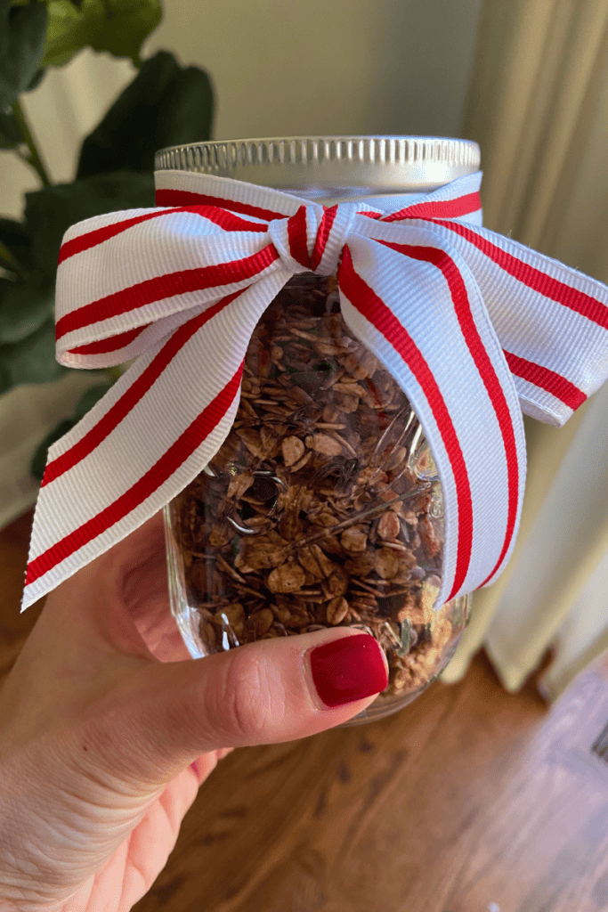 A Delicious Gingerbread Granola Recipe. Mason jar with granola and ribbon around the top.
