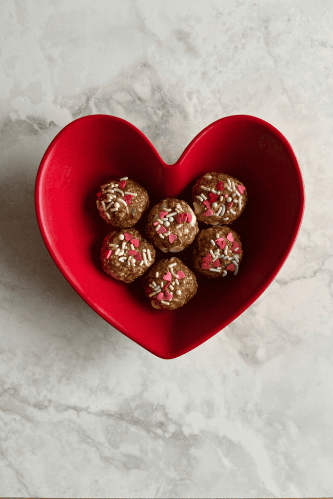No-Bake Healthy Protein Balls. Protein balls in red heart bowl.