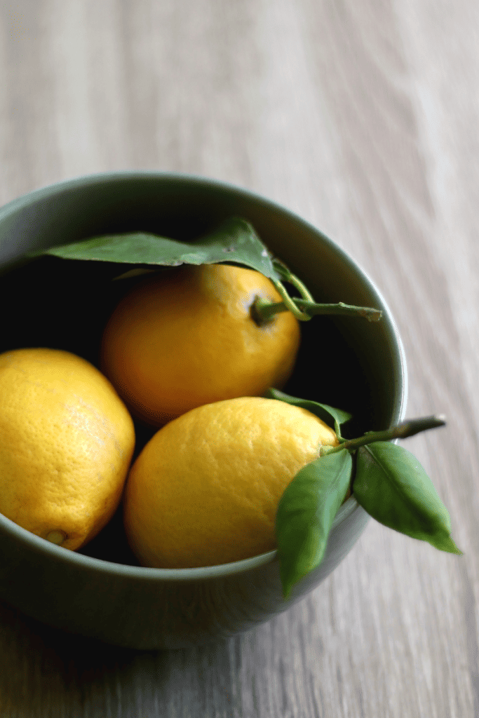 A Simple Guide to Spring Cleaning Your Home. Bowl of lemons on table.