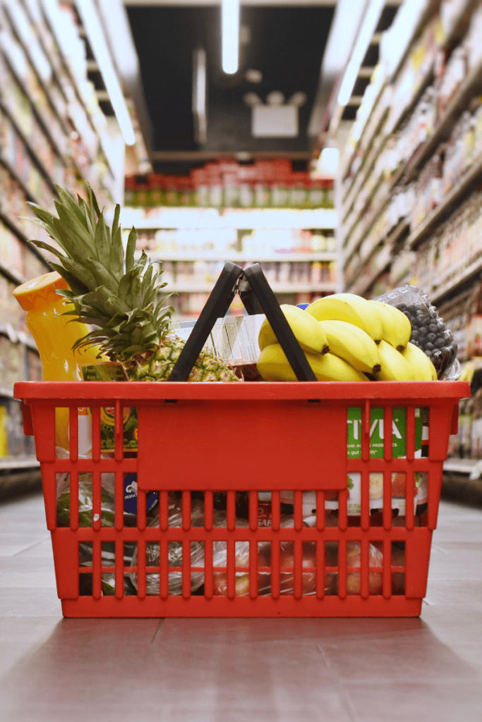 Gluten Free Snacks. Grocery store aisle with shopping basket full of food.
