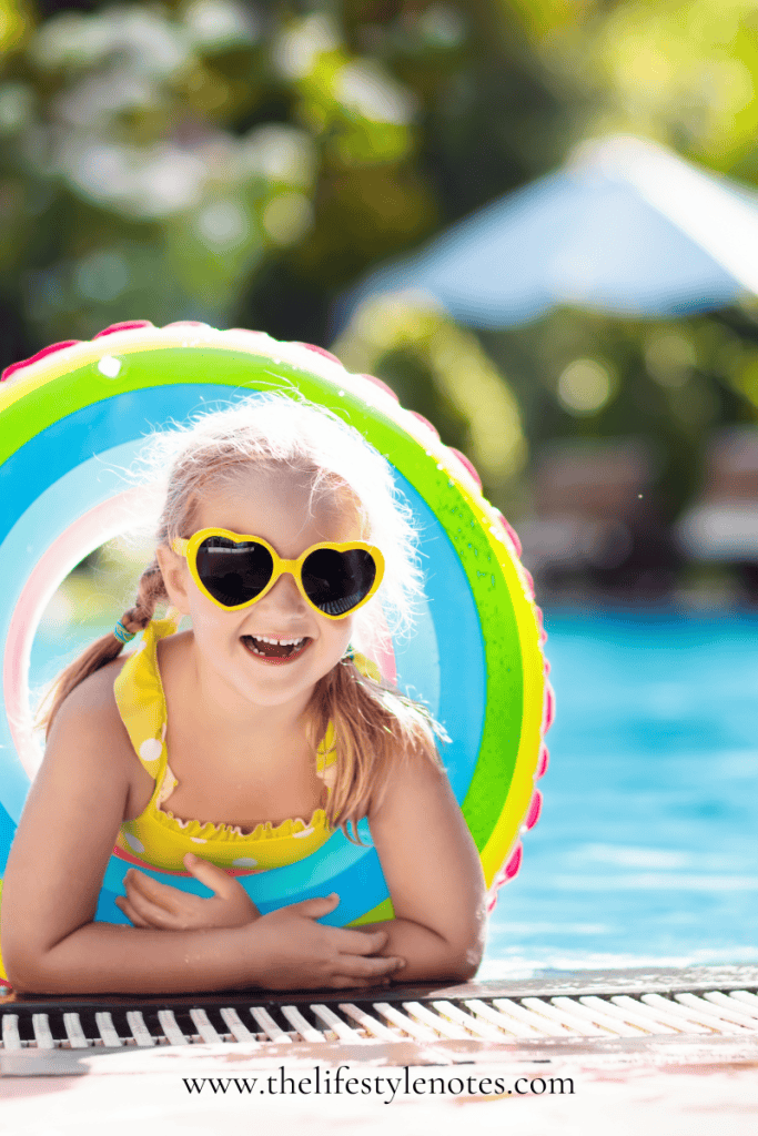 The Best Pool and Beach Gear for Families. Little girl in pool with tube and sunglasses.