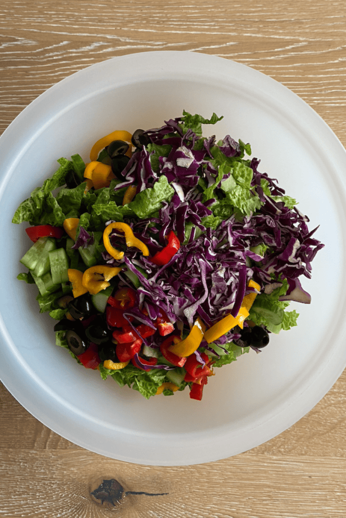 My Favorite Simple Chopped Salad. Bowl with chopped lettuce, cabbage, peppers, carrots and cucumbers.