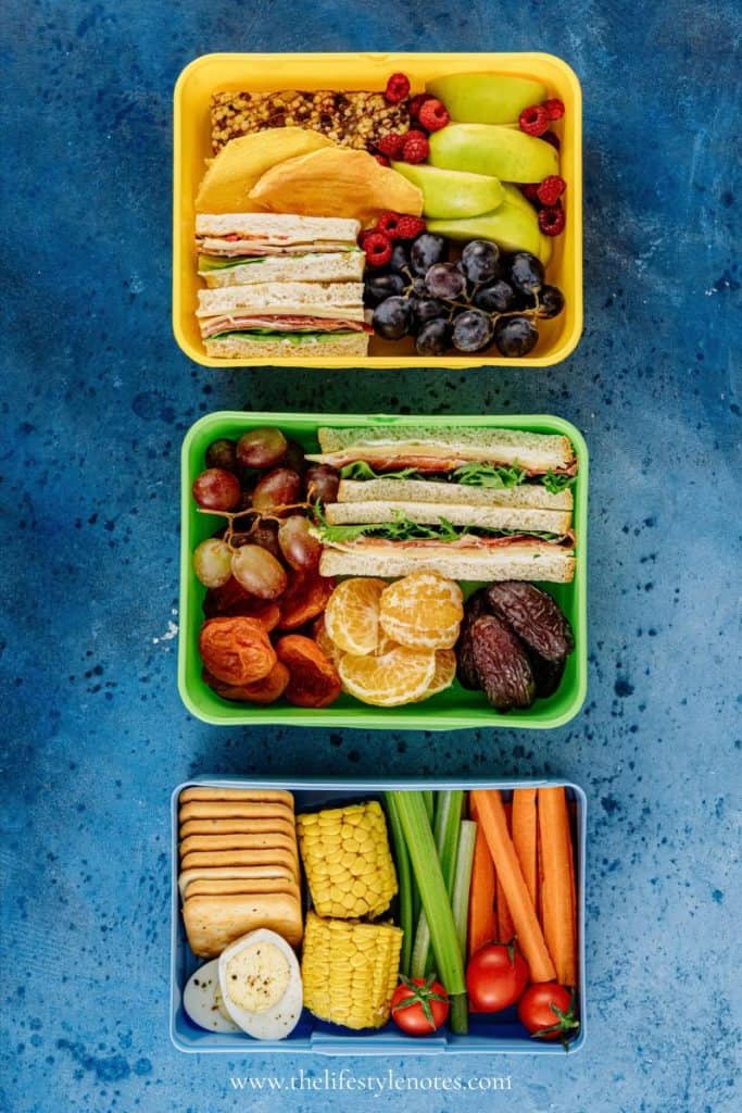 Easy Meals for On the Go. Three snack boxes with sandwiches, fruit, dried fruit, vegetables, crackers, granola bars.