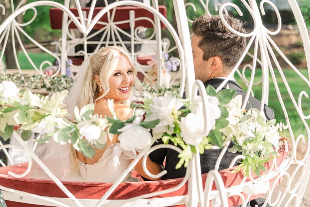 Bride looking back through the window of a horse drawn carriage.