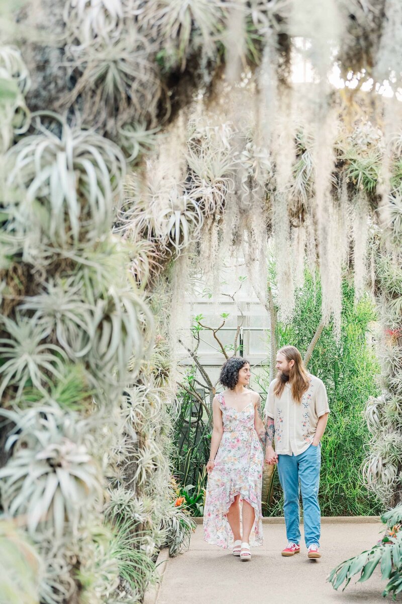 Couple walking hand-in-hand through the succulent arches in the Orchid Conservatory at Daniel Stowe Conservancy