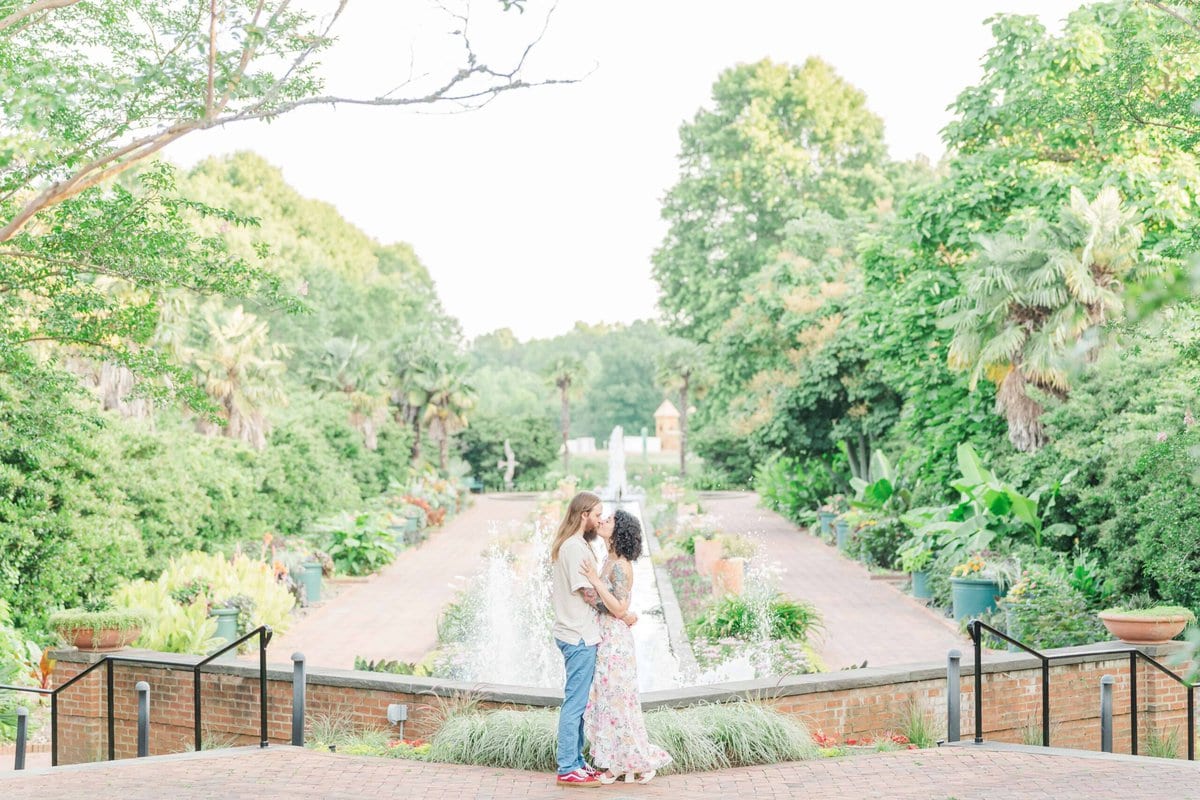 Engaged couple sharing a kiss during photo session at Daniel Stowe Conservancy