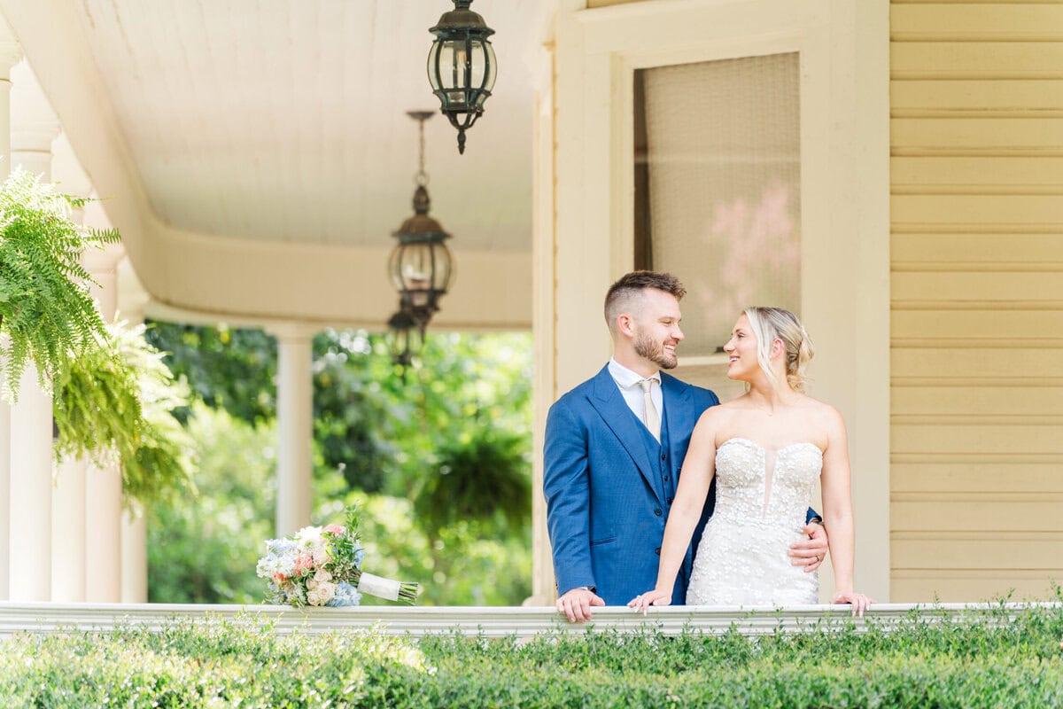 bride and groom in beautiful light on the porch of alexander homestead. Prioritize photography in your wedding budget to find a photographer who knows how to find light like this