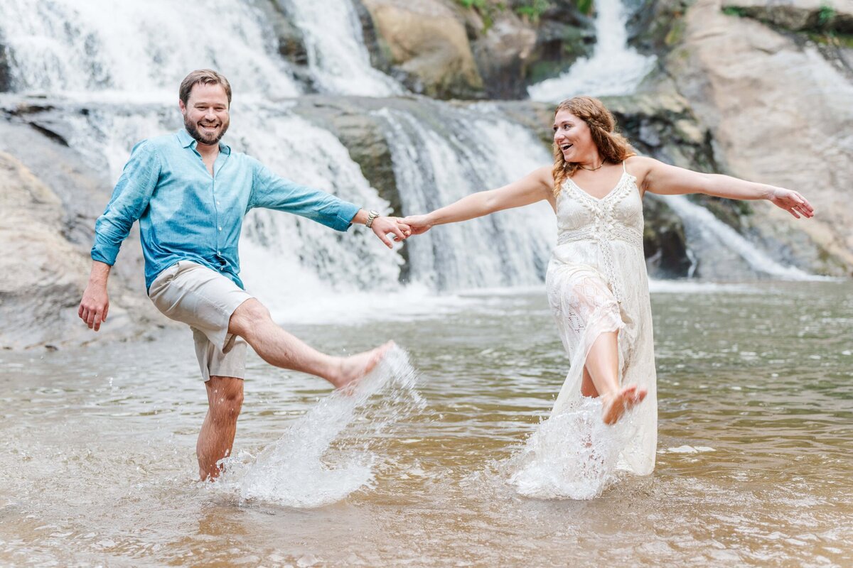 Adventure waterfall engagement photos North Carolina with couple splashing in the water