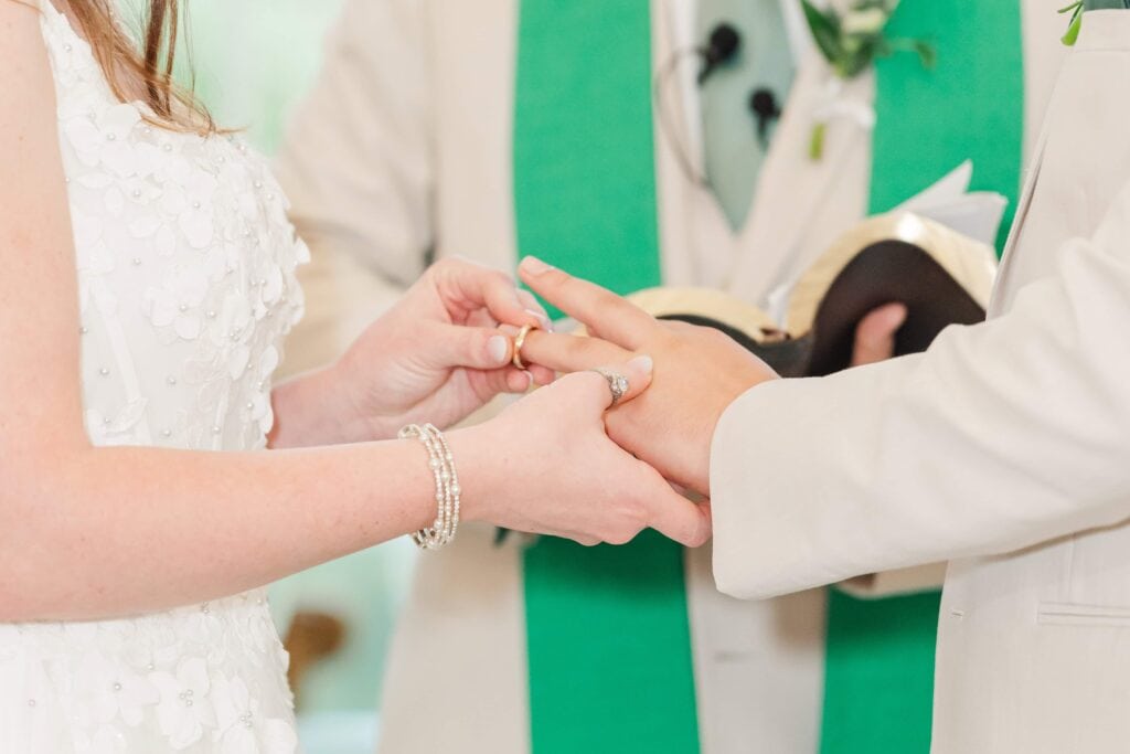 bride and groom exchanging rings during ceremony at Heron Hill Venue