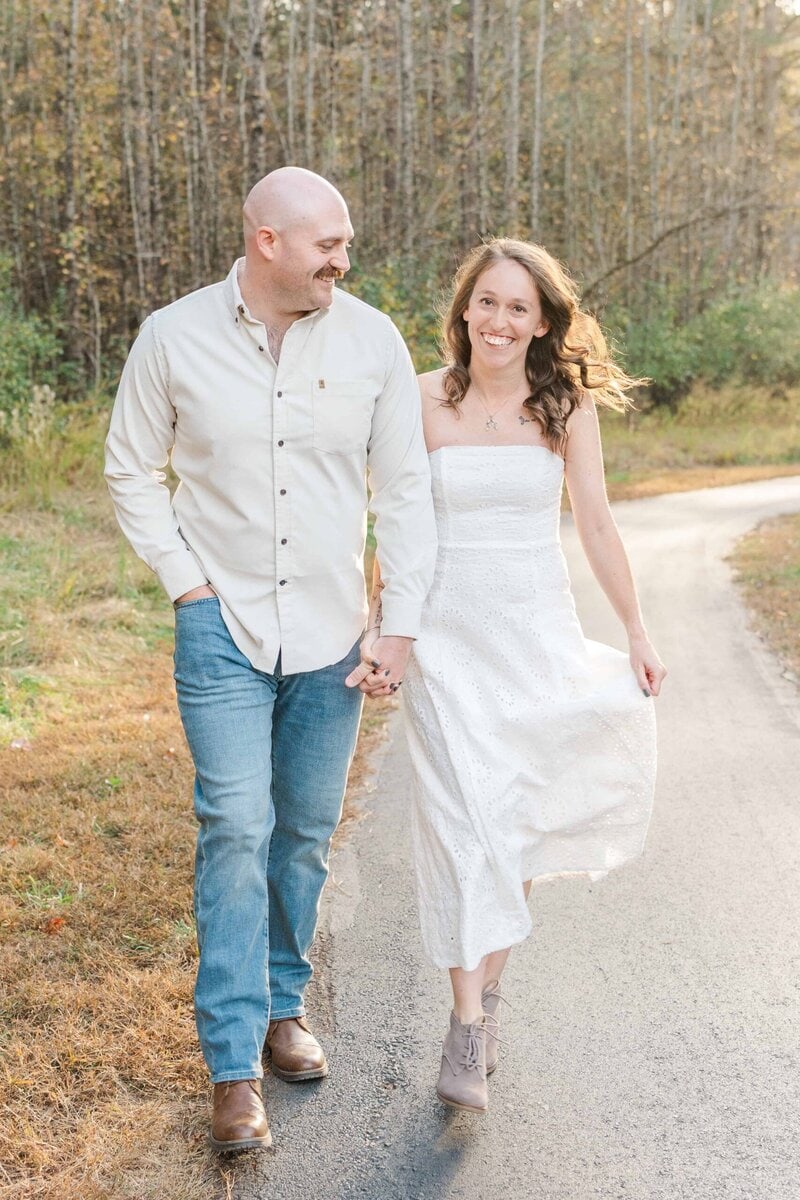 Engaged couple walking through open fields at Stevens Creek Nature Preserve
