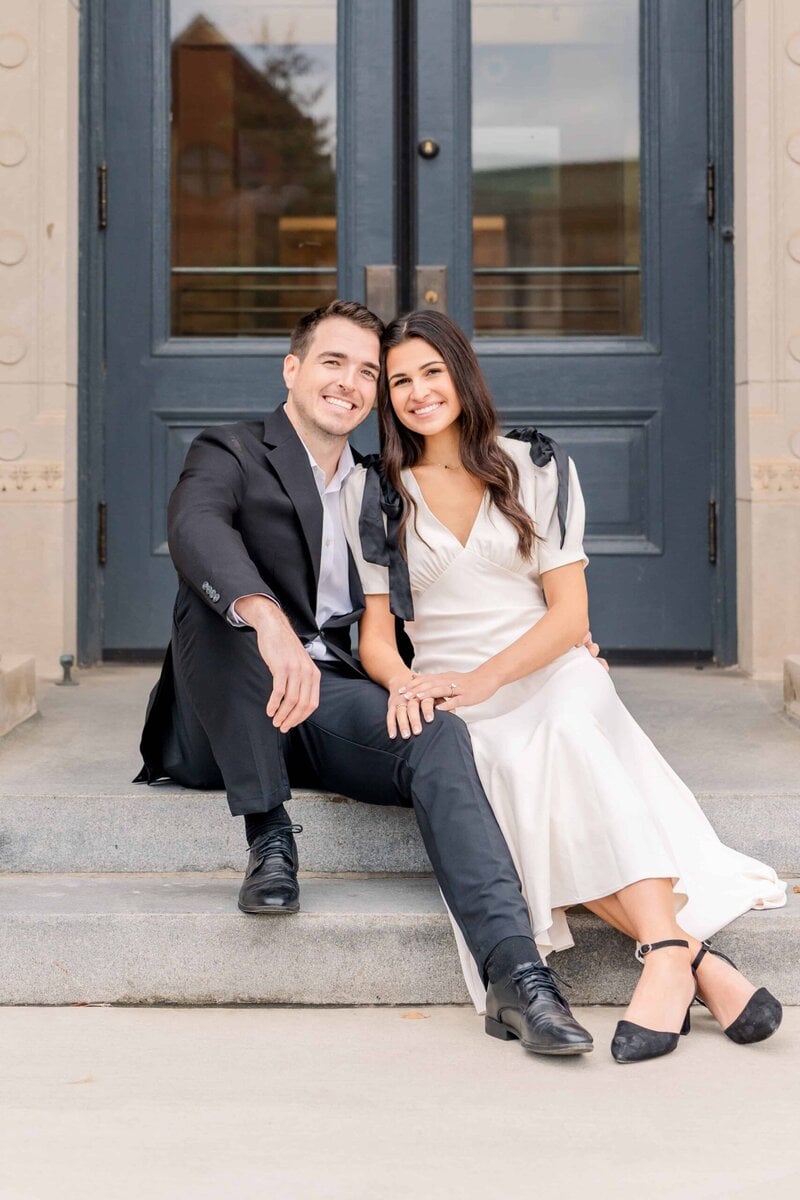 Alyssa and Matthew smiling together during Uptown Charlotte engagement photos
