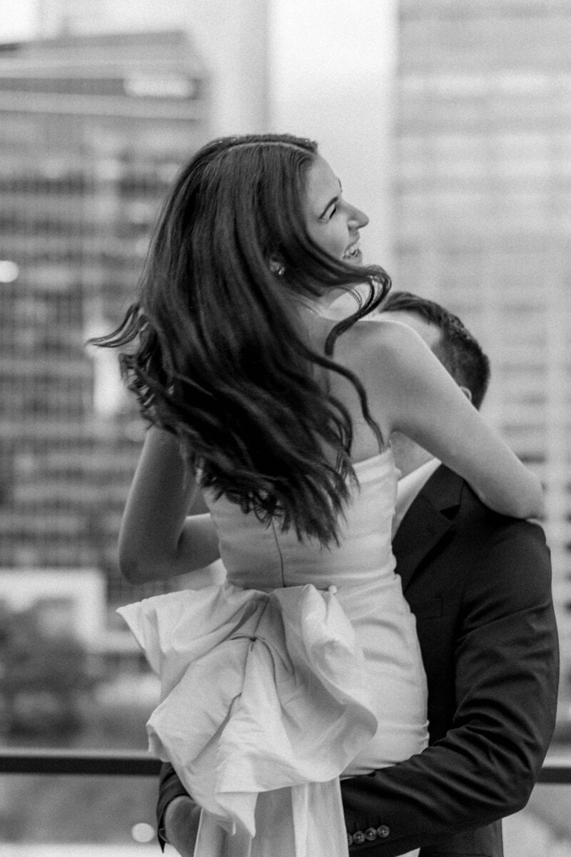 Engaged couple framed by tall city buildings in Uptown Charlotte