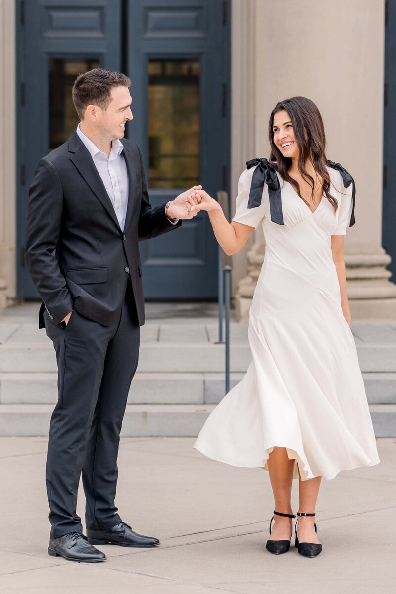 Engaged couple walking together in the heart of Charlotte near courthouse