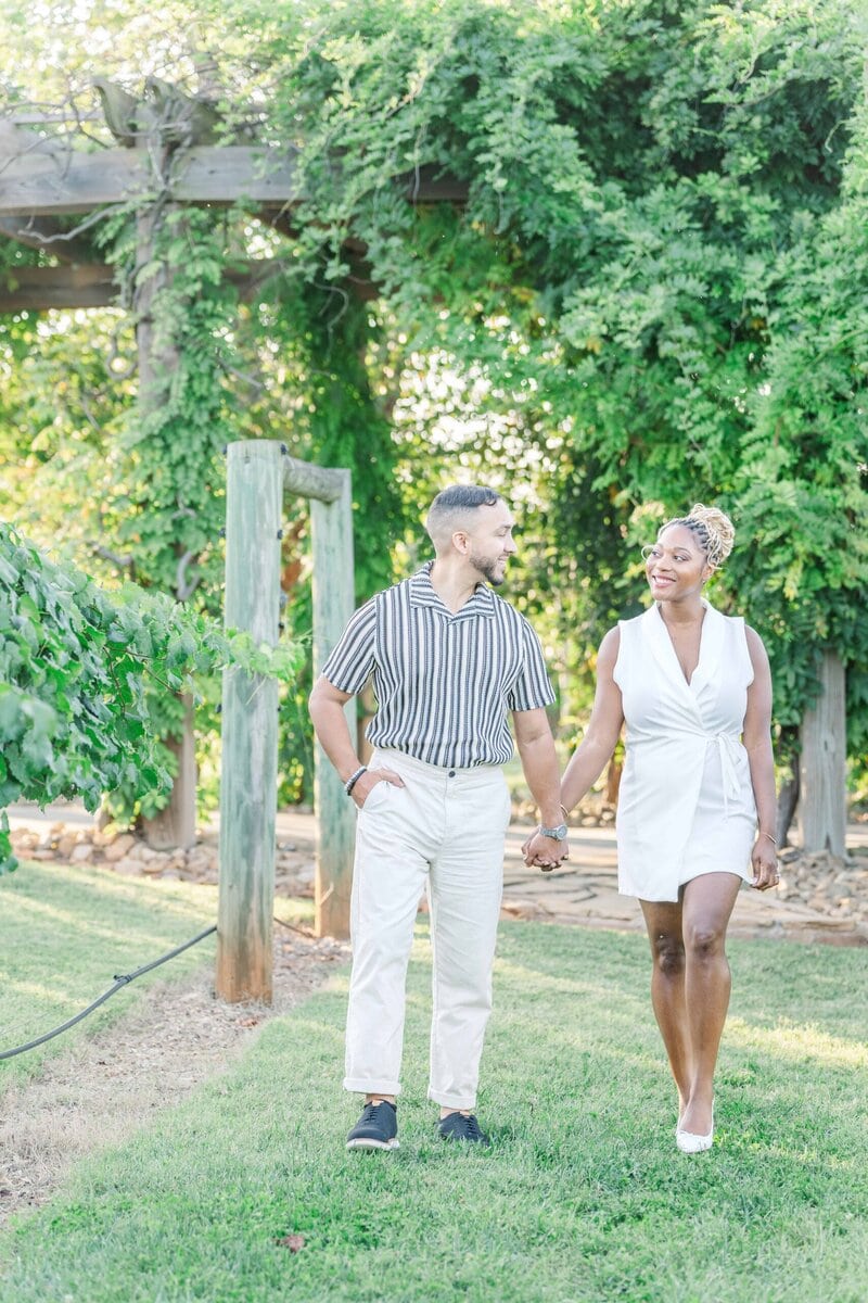 Coordinated neutral engagement outfits at a vineyard wedding venue in Shelby North Carolina.