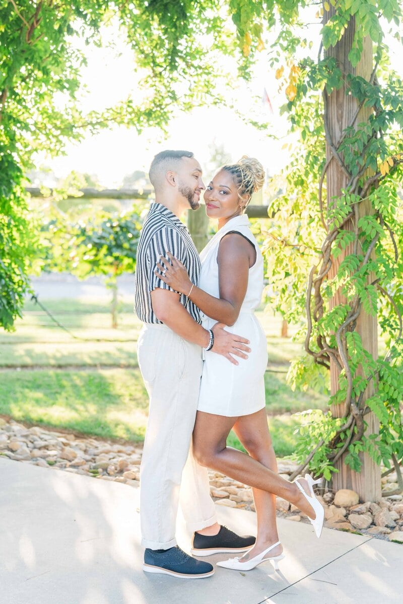 Juan in cream pants and a striped shirt standing with his fiancée at Spinning Leaf vineyard.