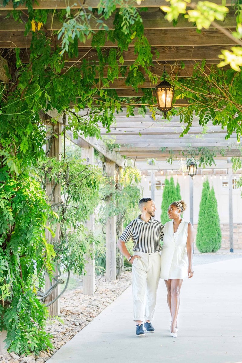 Bride to be in a white dress walking through the vines at Spinning Leaf at Wedgewood Weddings.