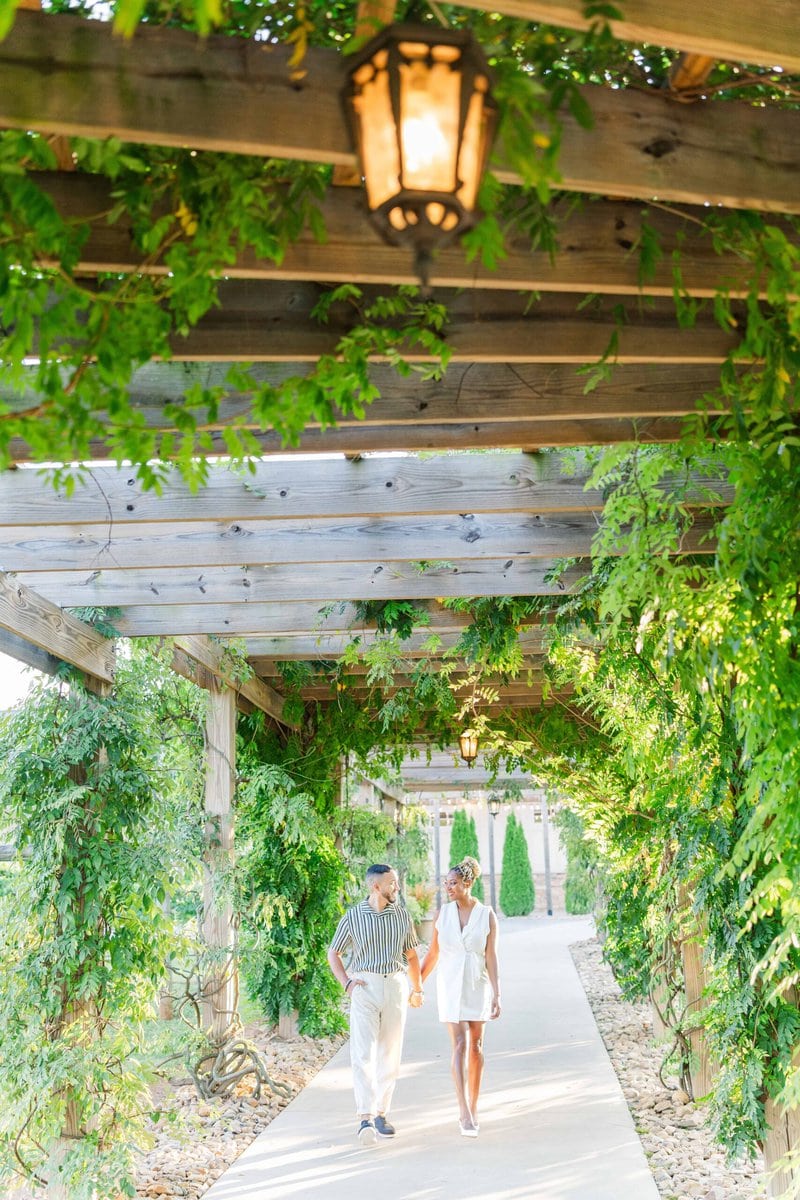 Couple walking together on the stone terrace at Spinning Leaf at Wedgewood Weddings with vineyard views in the background.