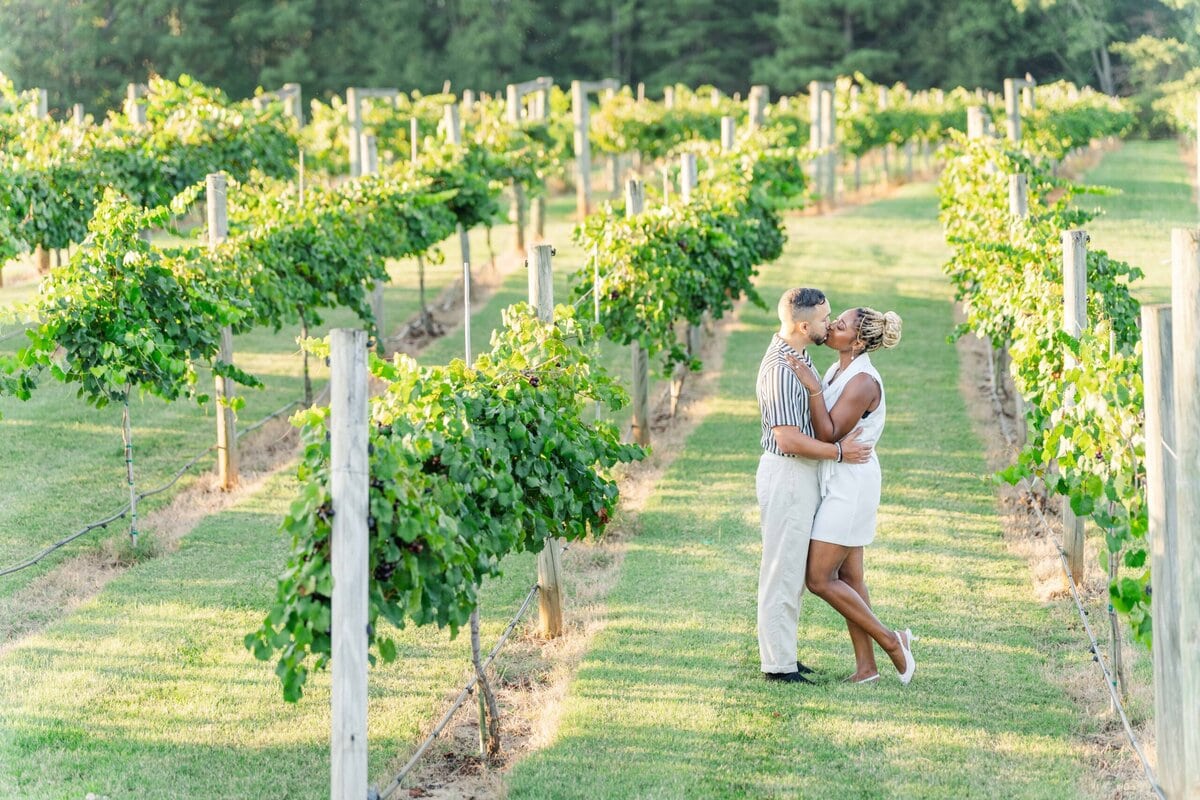 Romantic engagement session portrait at Spinning Leaf vineyard wedding venue with rolling vineyard views behind the couple.
