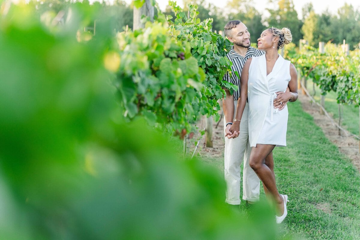 Gelisa and Juan laughing together in the vineyard at Spinning Leaf at Wedgewood Weddings in Shelby North Carolina.