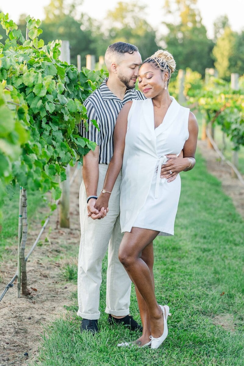 Couple dressed in complementary neutral tones for their engagement photos at a vineyard wedding venue.