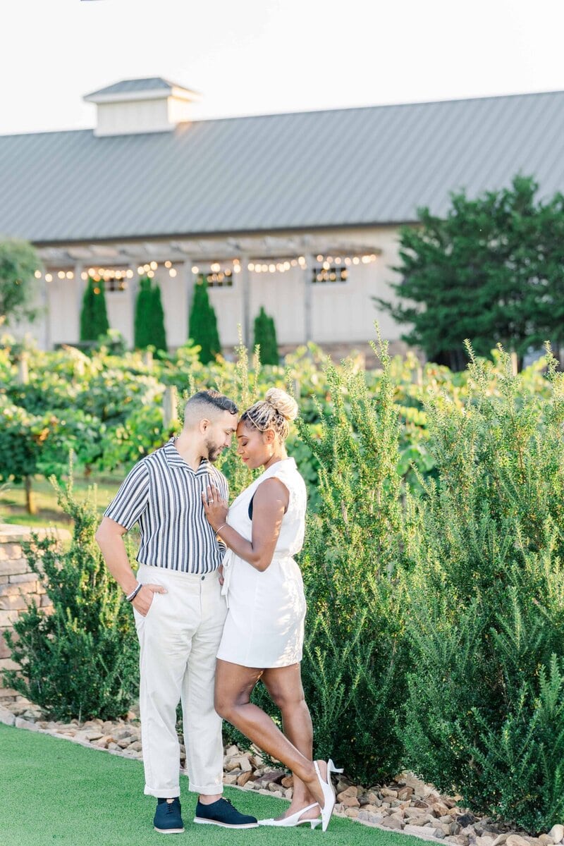 Gelisa and Juan with glowing string lights in the background at Spinning Leaf at Wedgewood Weddings creating an intimate atmosphere at this vineyard wedding venue.