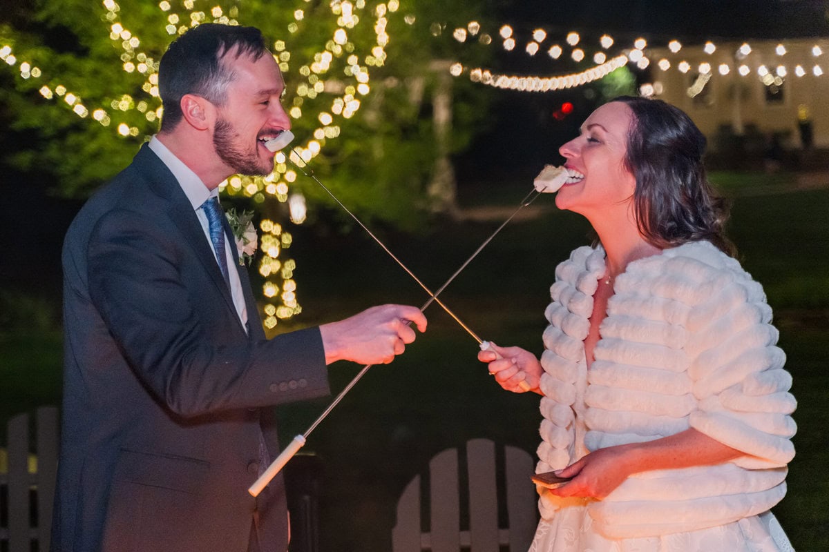 Bride and groom laughing together by campfire at Alexander Homestead wedding Charlotte NC