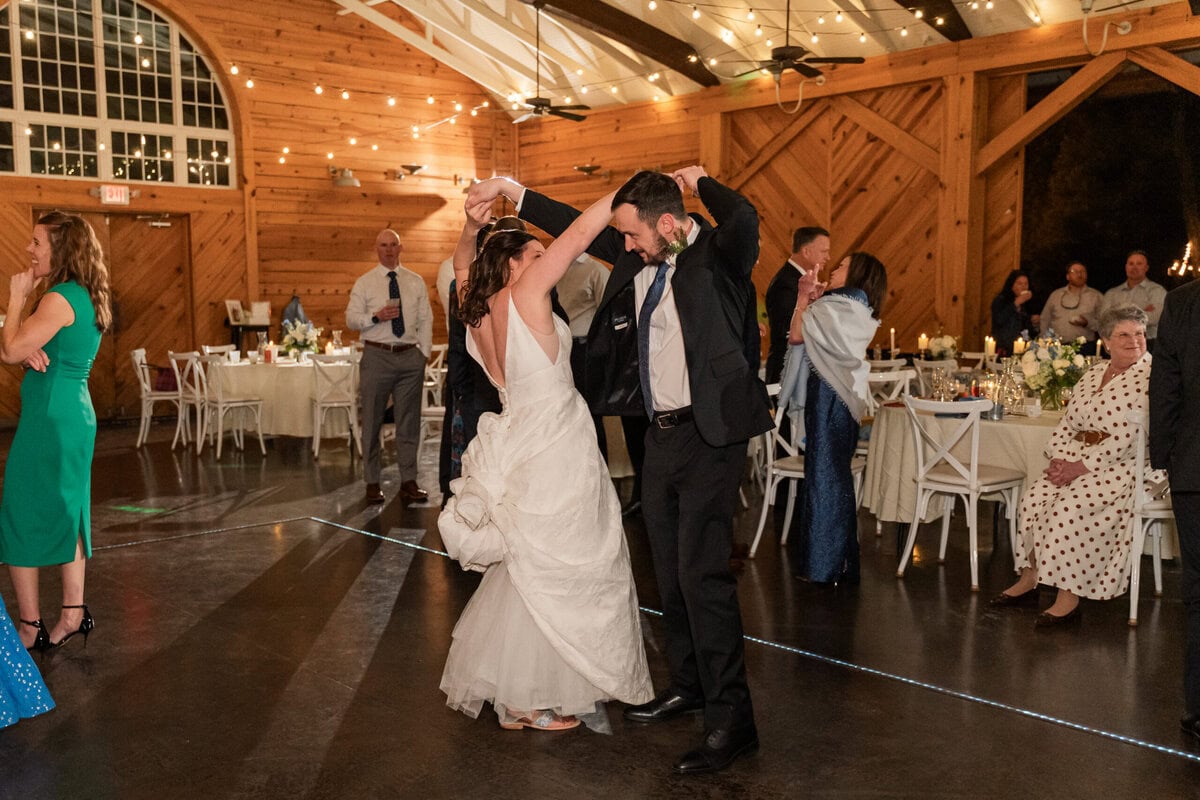 Bride laughing with knotted bustle resembling bunny tail at Charlotte NC wedding
