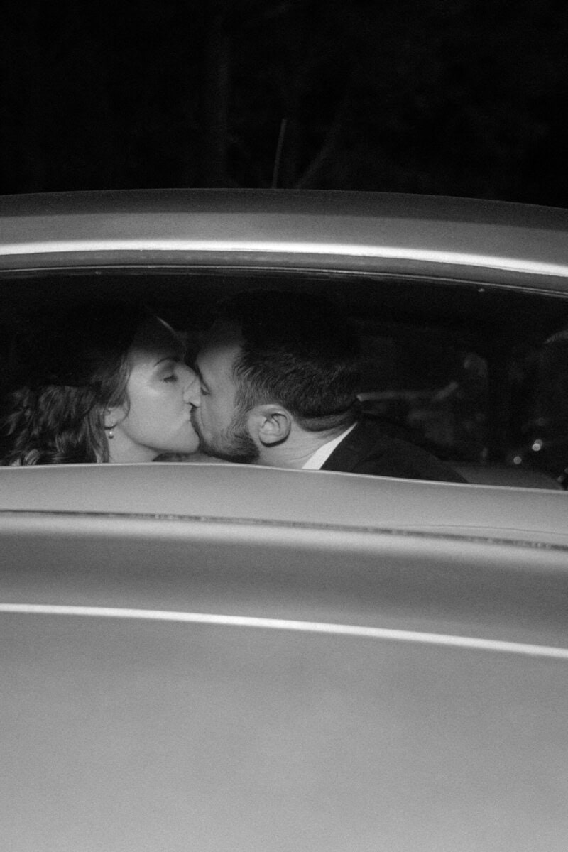 Bride and groom sharing a kiss inside a vintage car at Alexander Homestead.