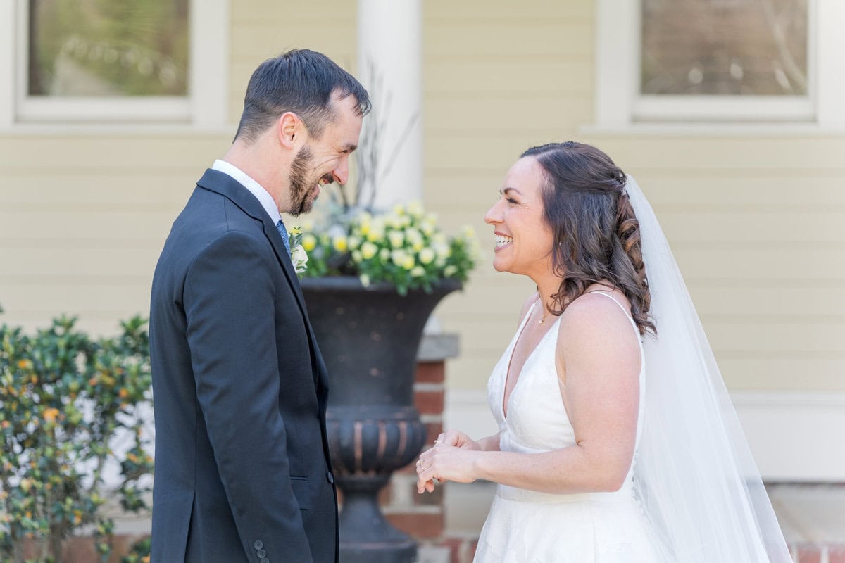 Groom seeing bride for first time during first look at back of Alexander Homestead manor
