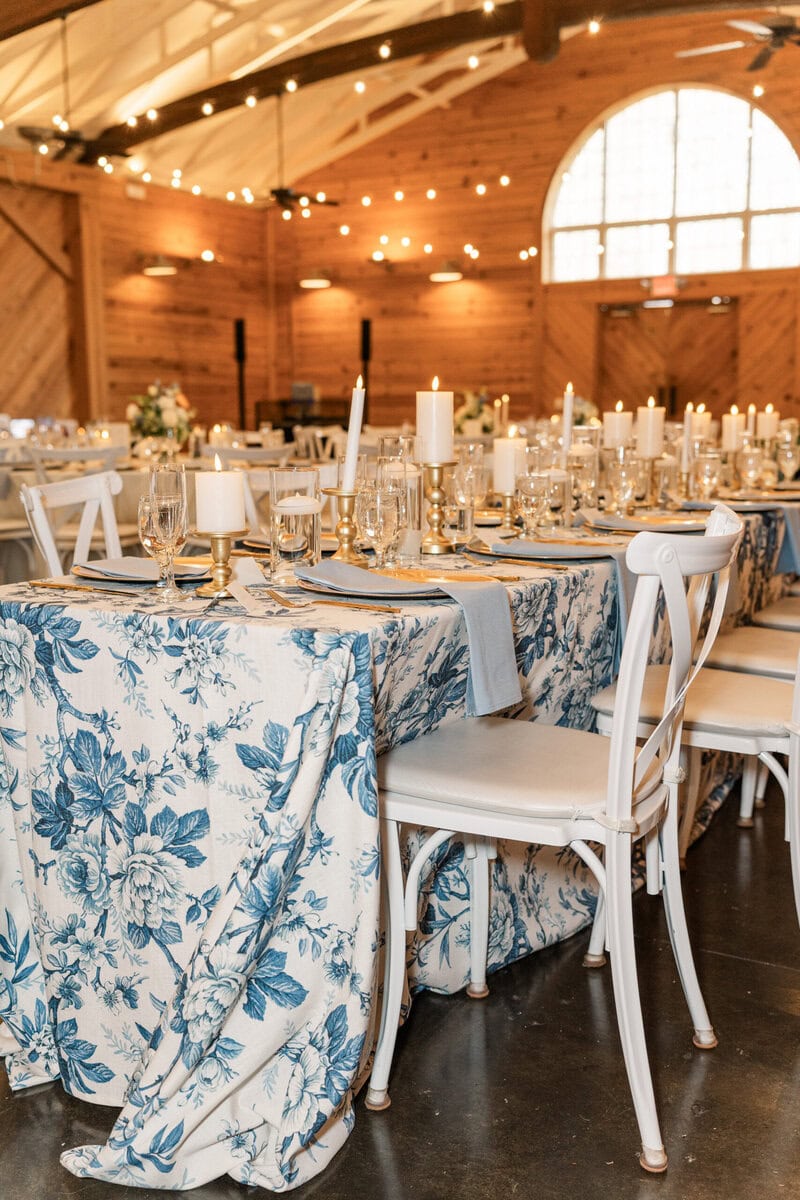 Wedding reception table with white floral linens white roses and blue hydrangeas at Alexander Homestead