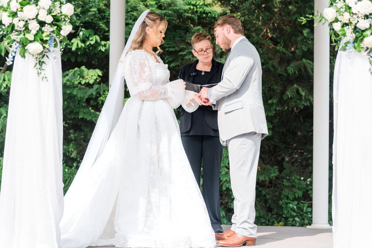 Bride and groom exchanging vows under the white garden pavilion at Alexander Homestead by Wedgewood Weddings Charlotte NC
