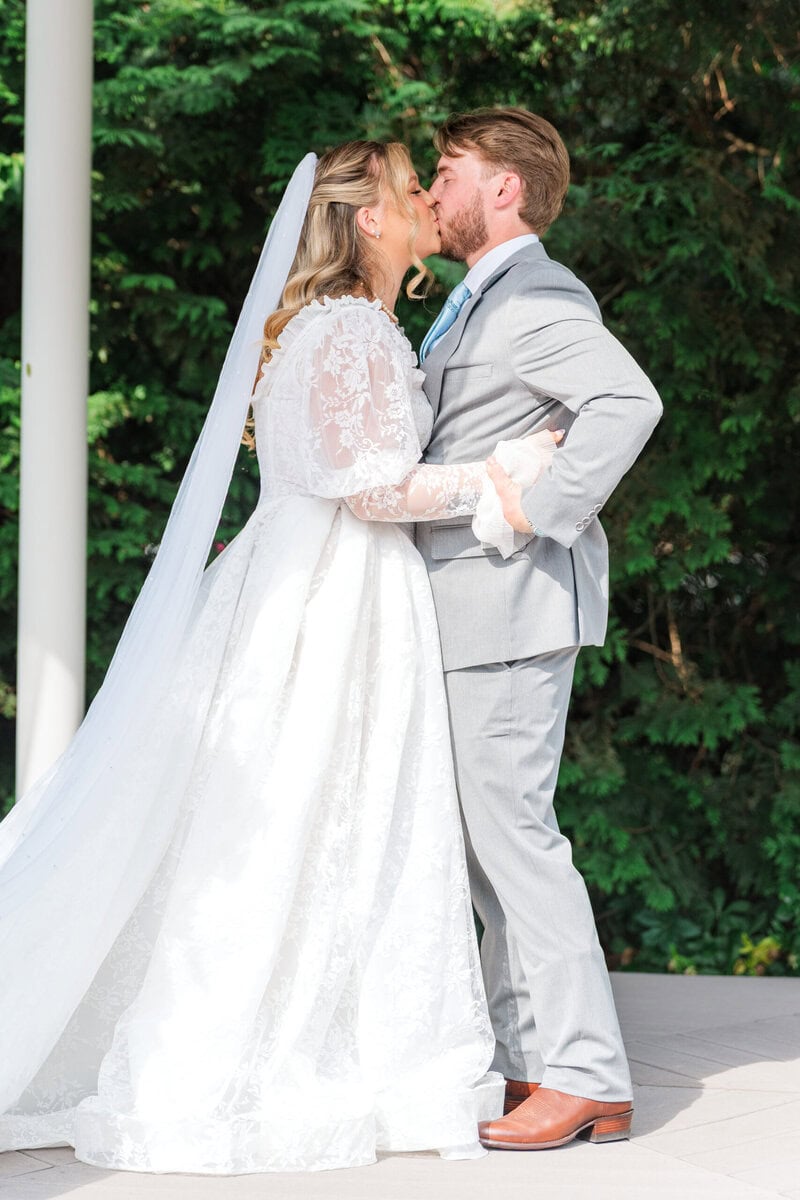 Bride and groom first kiss at the garden gazebo at Alexander Homestead, romantic wedding photos Charlotte NC