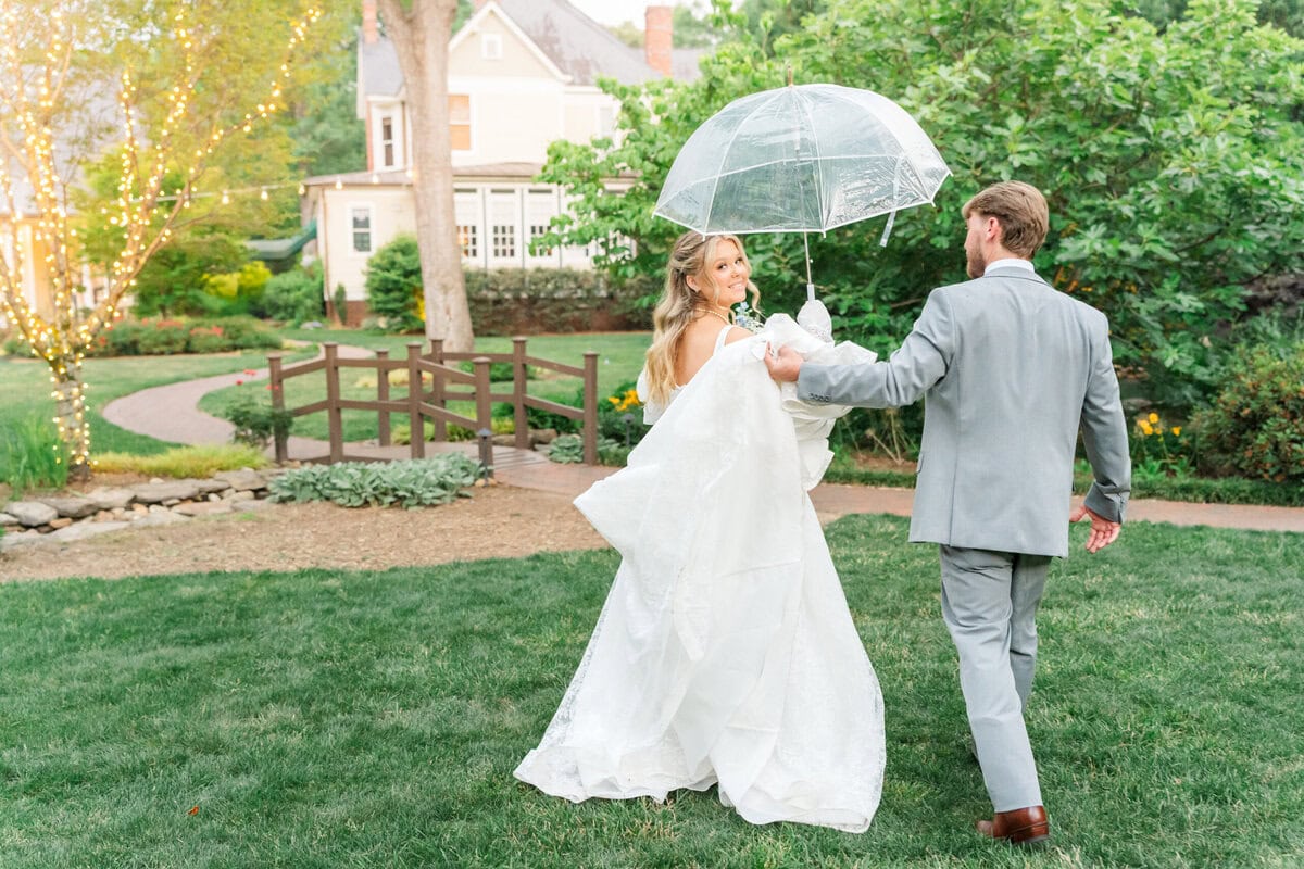 Bride Samantha looking over her shoulder in lace gown in the gardens of Alexander Homestead Charlotte NC