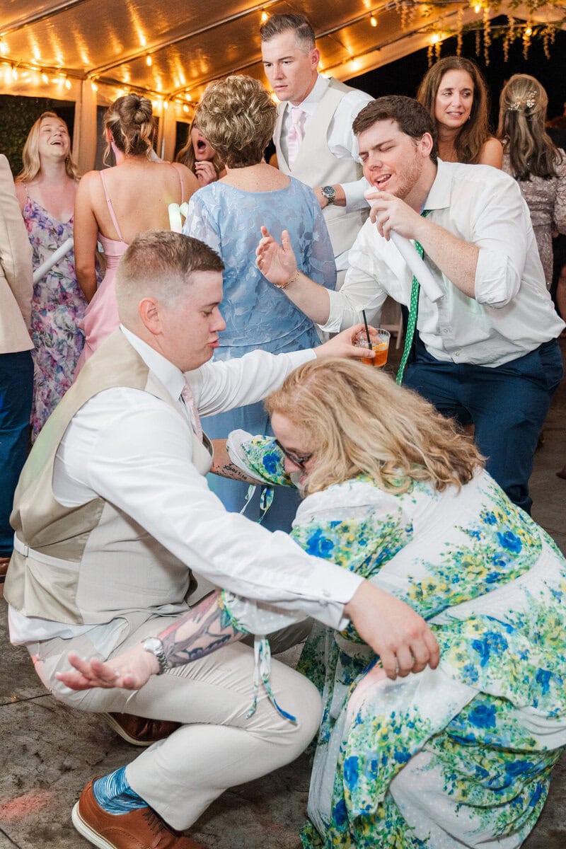 wedding guests dancing under tent at Mariposa Chapel little white chapel wedding near Charlotte