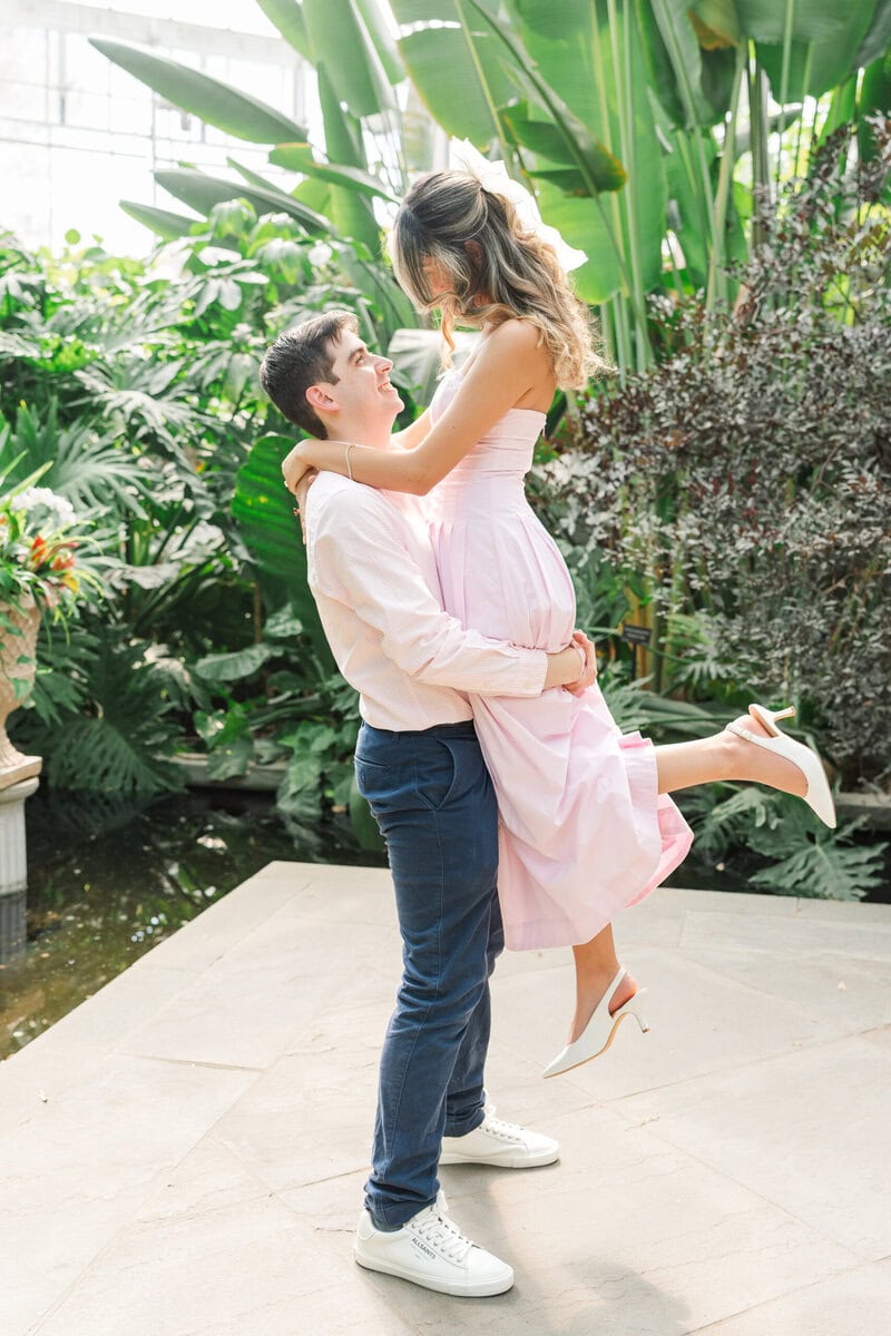 Engaged couple near the water feature area of the Orchid Conservatory at Daniel Stowe Botanical Garden Belmont NC photographed by The Lilac Lion Photography