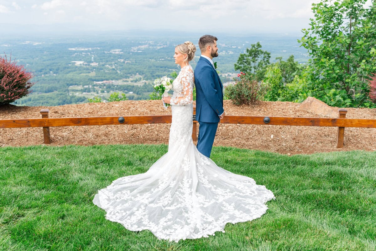 Bride and groom first touch outside Hidden Hill Venue Morganton NC with panoramic mountain backdrop