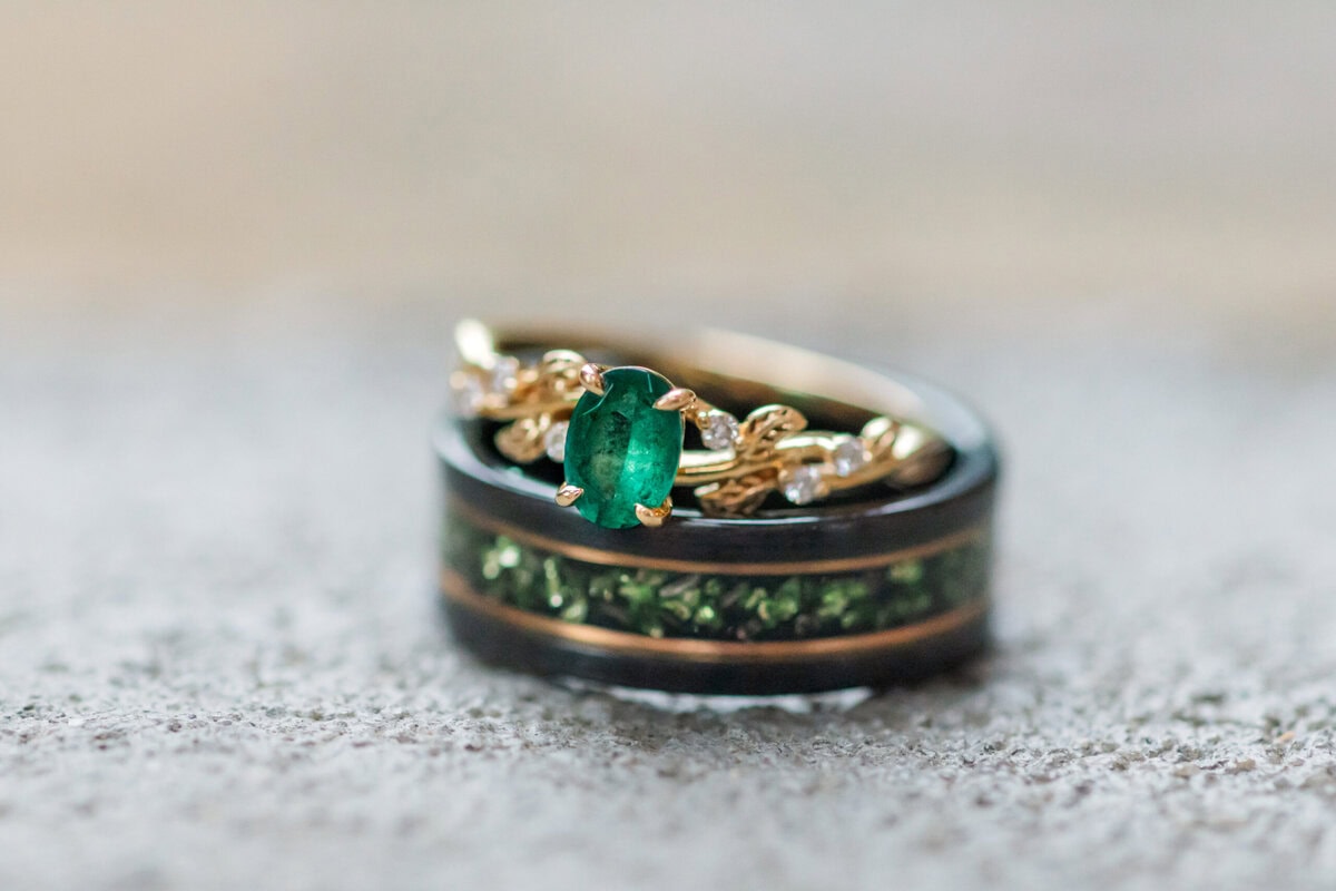 Close-up of emerald engagement ring during Providence Cotton Mill engagement session in North Carolina